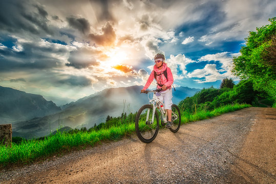 Girl mountain biking on a mountain road