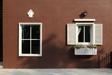 White window on brown concrete wall.