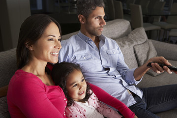 Fototapeta premium Hispanic Family Sitting On Sofa And Watching TV