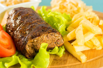 Meat, tomatoes, french fries and sauces
