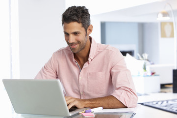 Man Working At Laptop In Home Office