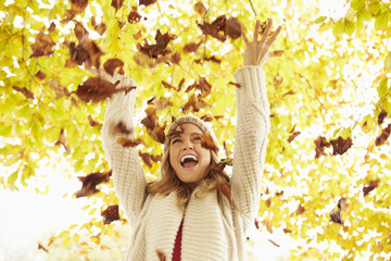 Woman Throwing Autumn Leaves Into The Air