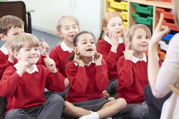 Pupils Copying Teacher's Actions Whilst Singing Song