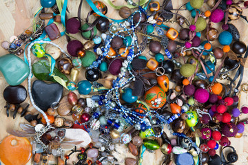 Heap of Jewelry with Gold Bracelets, Ruby . Top View of Necklace, Pearl and Gem Beads isolated on wooden background