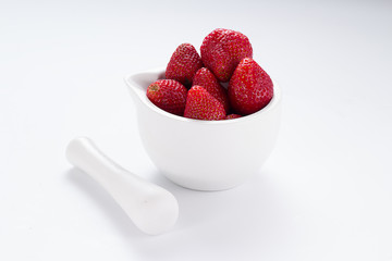 Small white china bowl filled with succulent juicy fresh ripe red strawberries isolated