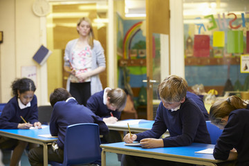Elementary School Pupils Sitting Examination In Classroom