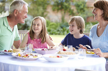 Grandparents With Grandchildren Enjoying Outdoor Meal