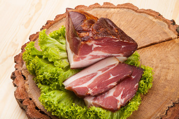 Smoked meat with bright summer vegetables on wooden background