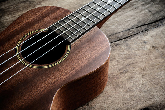 Close up of ukulele on old wooden background