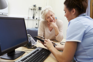 Obraz premium Nurse Showing Patient Test Results On Digital Tablet