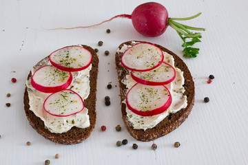 Rye bread sandwich with cream cheese and radish.
