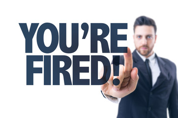 Business man pointing the text: You're Fired!