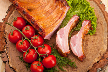 Smoked meat with bright summer vegetables on wooden background