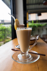 A cup of hot cappuccino with Chocolate banana smoothie and bread