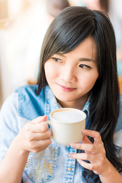 Beautiful cute girl in the cafe with white coffee cup