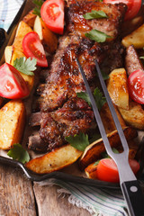 BBQ pork, potatoes and tomatoes on a grill pan. vertical top view
