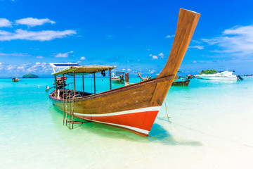 Fototapeta na wymiar Wood boat and islands in andaman sea against blue sky at Lipe