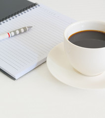 Coffee cup with note book and pencil
