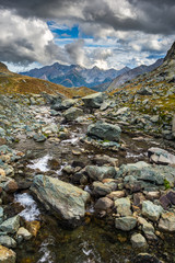 High altitude alpine stream with dramatic sky