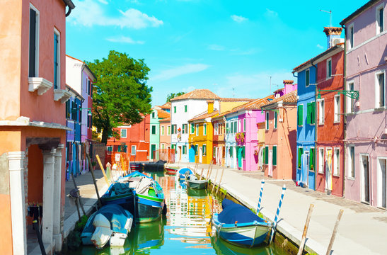 Narrow canal and colorful houses in Burano, Italy.