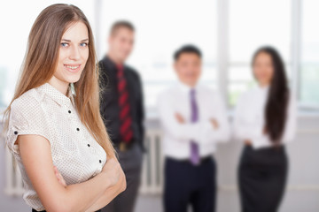 Successful business woman at foreground and business team at background