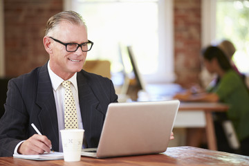 Man Working At Laptop In Contemporary Office