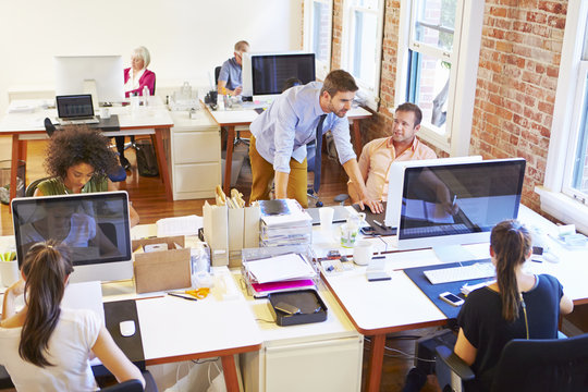 Wide Angle View Of Busy Design Office With Workers At Desks