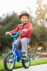 Young Boy Riding Bike In Park