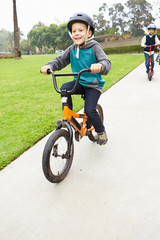 Fototapeta premium Young Boy Riding Bike In Park