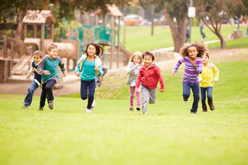 Group Of Young Children Running Towards Camera In Park