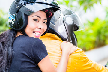 Asian couple riding motorcycle