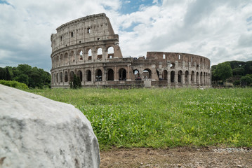 Fototapeta na wymiar Coliseo Romano desde el Foro Romano con piedra en primer plano
