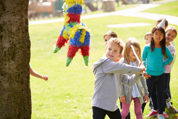 Children Hitting Pinata At Birthday Party © Monkey Business