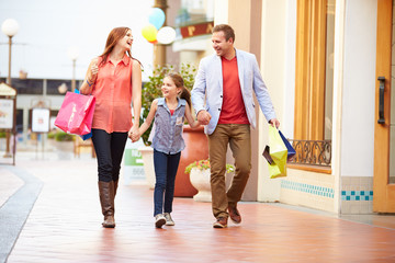 Fototapeta premium Family Walking Through Mall With Shopping Bags