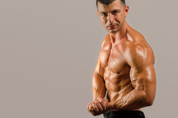 Fototapeta premium Bodybuilder topless, flexing his muscles. Strong man with perfect abs, shoulders,biceps, triceps and chest