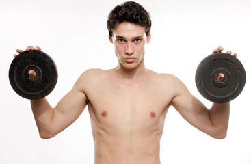 Fototapeta na wymiar Skinny man training his bicep muscle. Beautiful teenager lifting two dumbbells.Anorexic young man training to become stronger