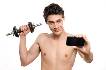 Fototapeta na wymiar Skinny man taking a selfie with his phone while training his bicep muscle. Beautiful teenager lifting a dumbbell and taking a photo for facebook.Anorexic young man training to become stronger