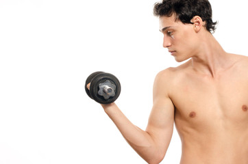 Fototapeta na wymiar Skinny man training his bicep muscle. Beautiful teenager lifting a dumbbell.Anorexic young man training to become stronger