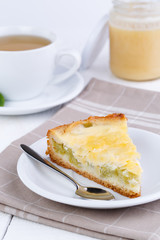 Tasty slice of rhubarb pie on white wooden table.