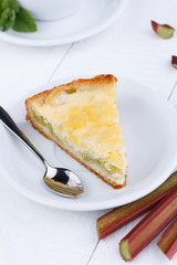 Tasty slice of rhubarb pie on white wooden table.