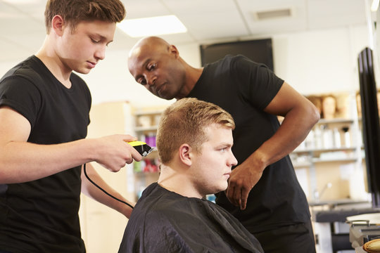Teacher Helping Students Training To Become Hairdressers