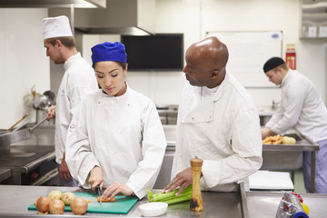 Teacher Helping Students Training To Work In Catering