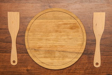 round cutting board and blades on a wooden background