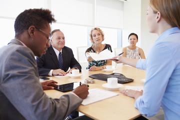 Five Businesspeople Having Meeting In Boardroom