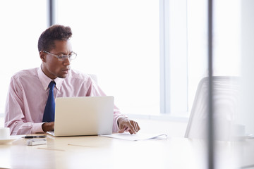 Businessman Working On Laptop At Boardroom Table