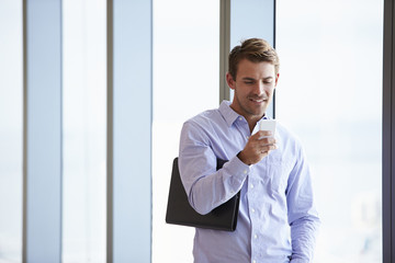 Fototapeta premium Casually Dressed Businessman Using Mobile Phone In Office