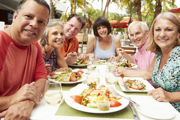 Group Of Senior Friends Enjoying Meal In Outdoor Restaurant