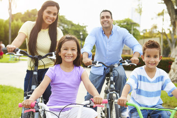 Obraz premium Parents With Children Riding Bikes In Park