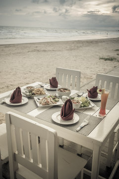 romantic dinner table setup on tropical beach , Vintage style