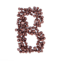 Alphabet from chocolate chips on white background